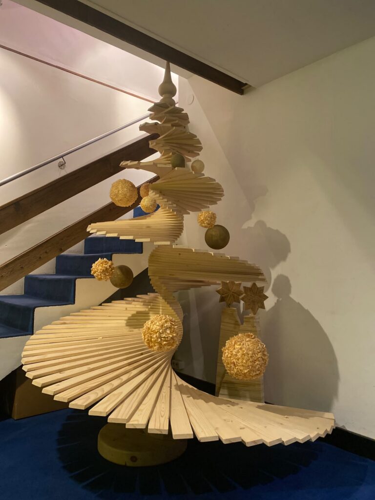 Design-Weihnachtsbaum aus Holz mit gedrechselten Kugeln, Stern und gold umwickelten Anhängern